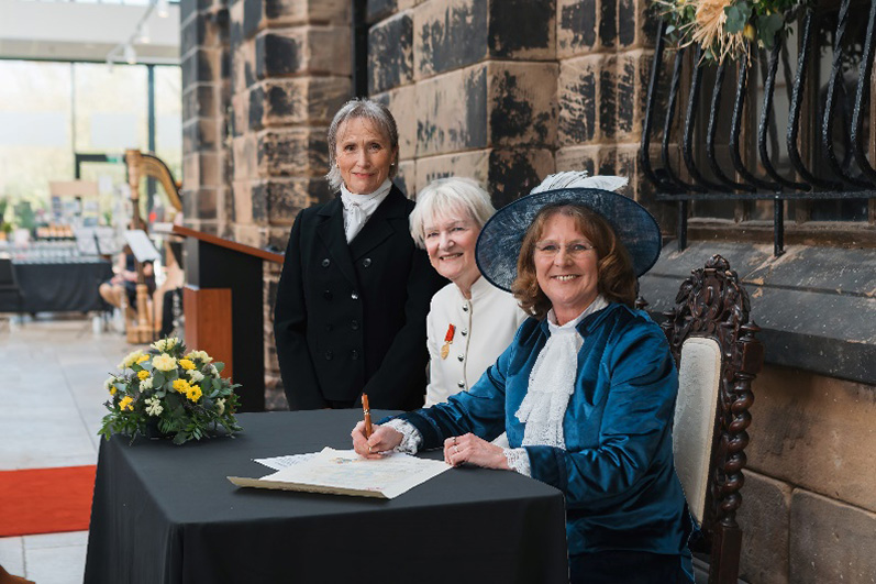 New High Sheriff Lynn Pegler signs her declaration, witnessed by Chair of the Cheshire Magistrates Bench, Patricia Peters, and Cheshire Under Sheriff, Darlene Storrar.